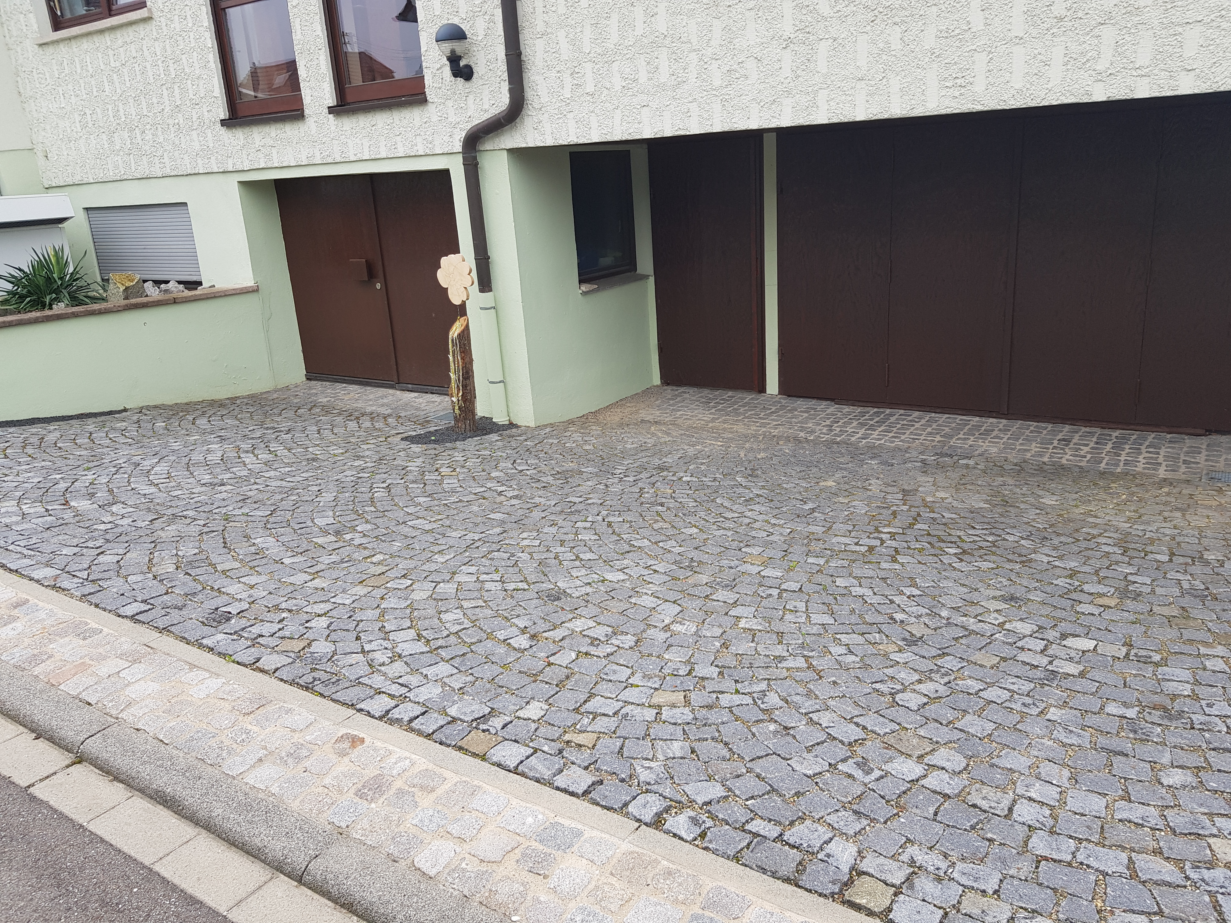 Garageneinfahrt mit Naturstein verlegt in Segmentbogen